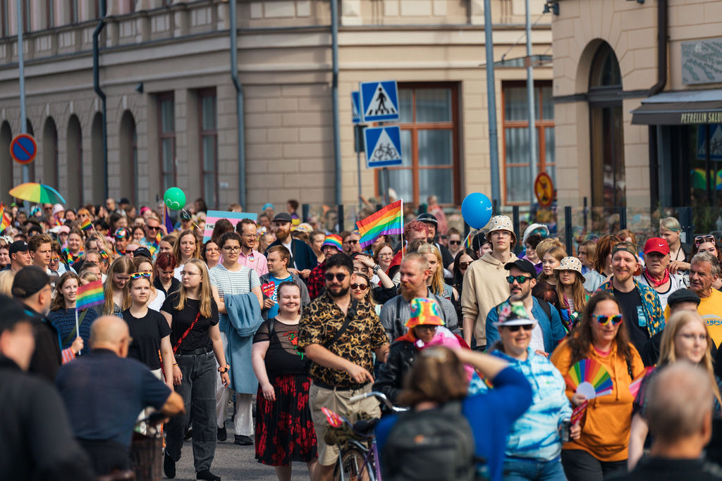 Joukko ihmisiä kävelemässä Oulussa Rantakadulla Oulu Pride kulkueessa